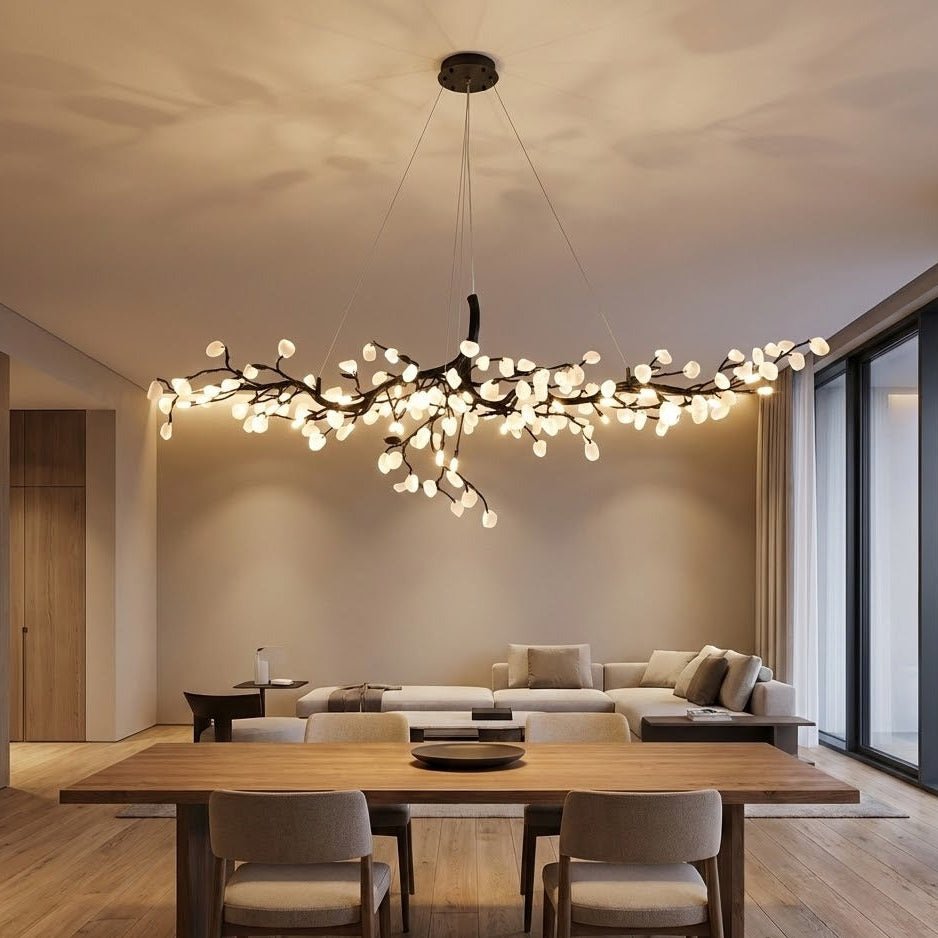 Luxury branch chandelier with glowing glass elements suspended above a modern dining table, blending seamlessly into an elegant open-concept living and dining room