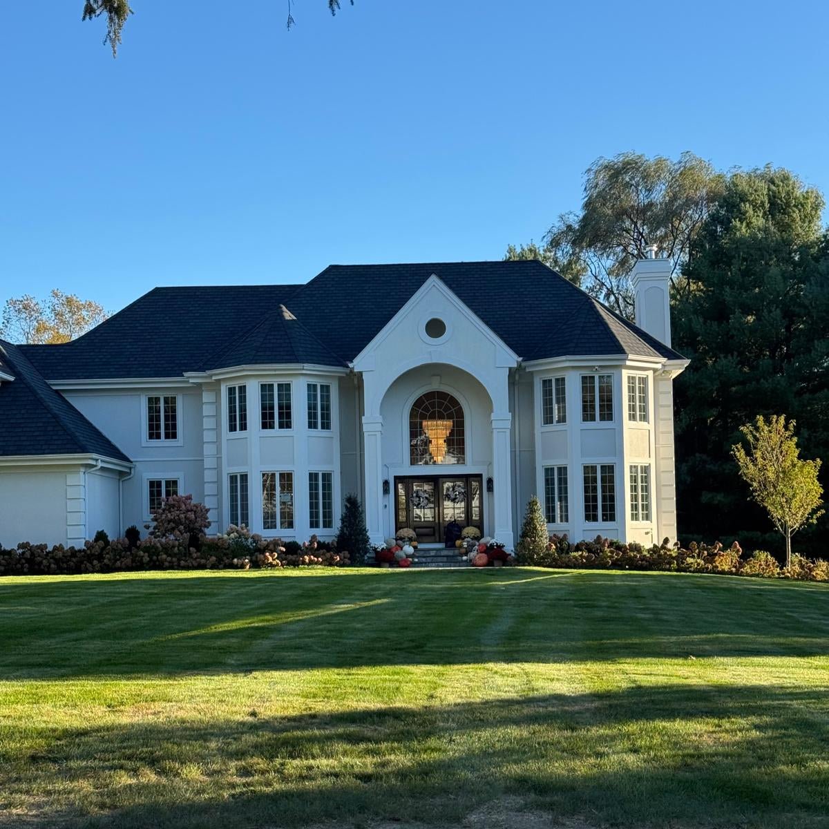 Luxury mansion exterior showcasing the Blanche tiered Murano glass chandelier glowing inside a grand foyer